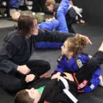 Michelle helping the kids in the kids bjj class